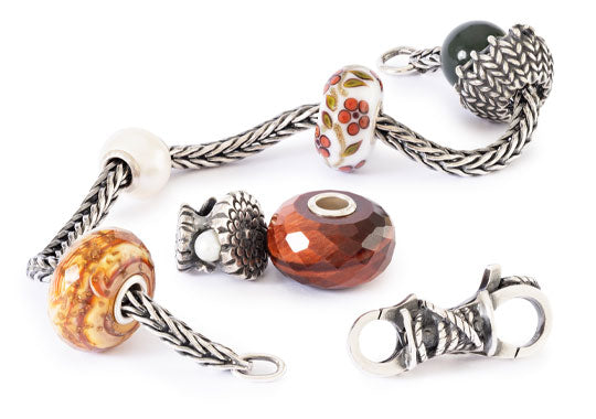 Bracelet with various beads and charms on a white background, inspired by autumn and hygge